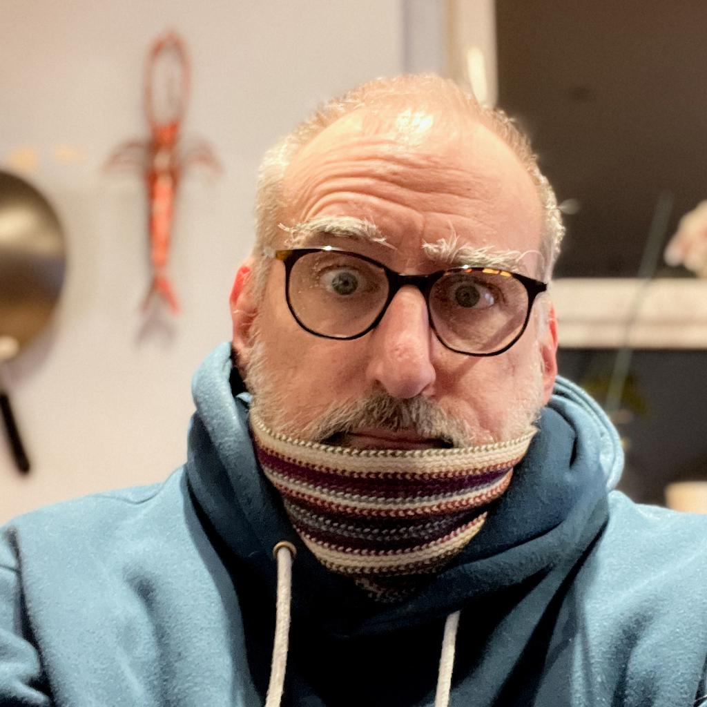 Norm selfie in a blue hoodie and a scarf.