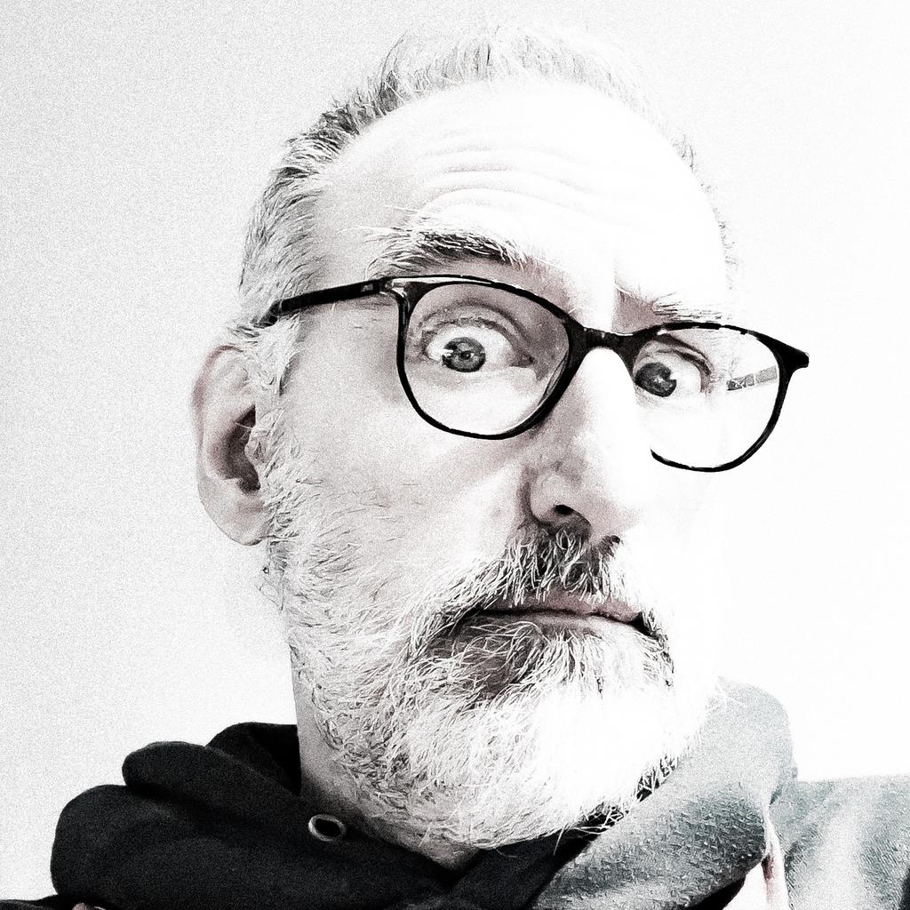 High contrast, slightly blown out, mostly black and white portrait of Norm, looking very skeptical.